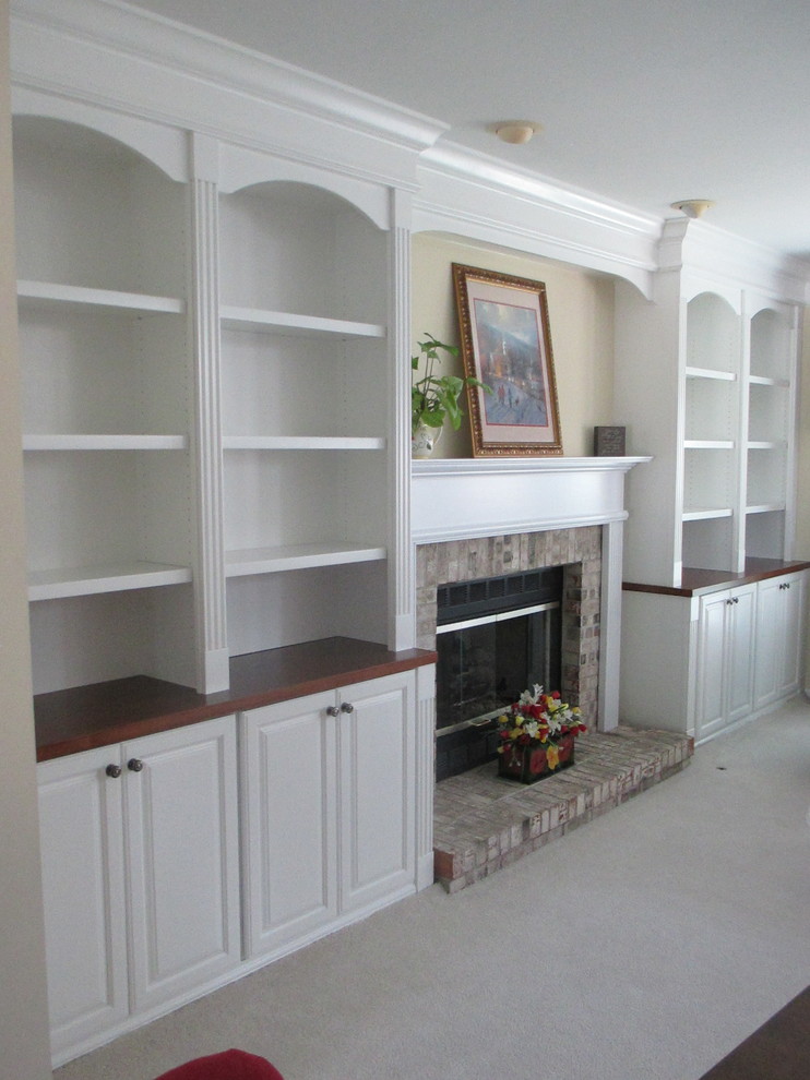 Imagen de sala de estar con biblioteca clásica con paredes beige, moqueta, todas las chimeneas y marco de chimenea de madera