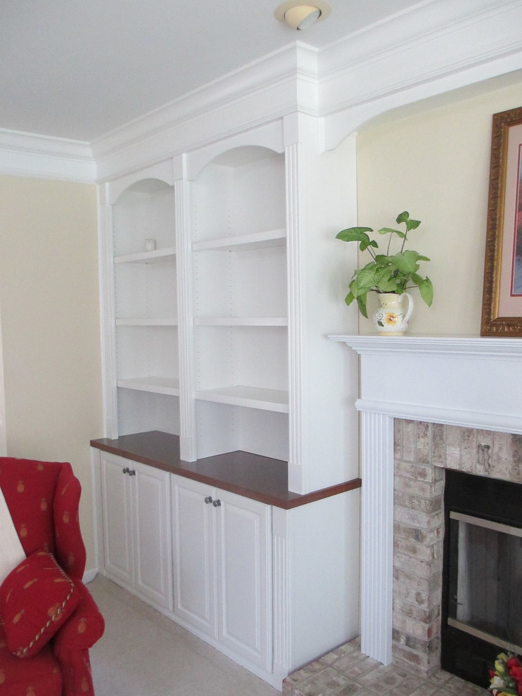 Aménagement d'une salle de séjour classique avec une bibliothèque ou un coin lecture, un mur beige, moquette, une cheminée standard et un manteau de cheminée en bois.