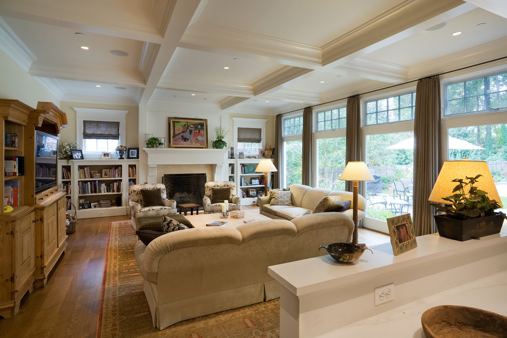 Imagen de sala de estar abierta tradicional con paredes beige, suelo de madera en tonos medios, todas las chimeneas y marco de chimenea de madera