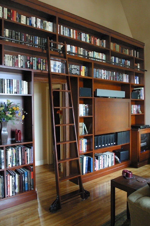 Cette photo montre une très grande salle de séjour chic ouverte avec une bibliothèque ou un coin lecture et un téléviseur encastré.