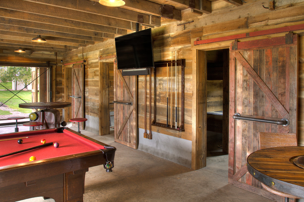 Foto di un grande soggiorno country aperto con sala giochi, pareti marroni, pavimento in cemento, TV a parete e pavimento grigio