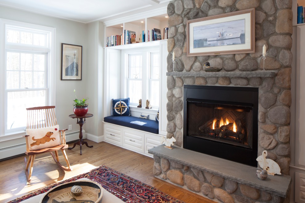Example of a mid-sized country open concept medium tone wood floor family room design in Portland Maine with white walls, a standard fireplace, a stone fireplace and a concealed tv
