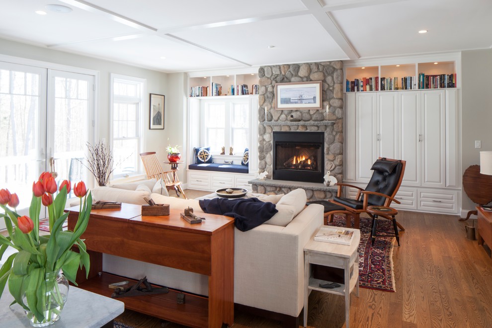 Mittelgroßes, Offenes Landhausstil Wohnzimmer mit weißer Wandfarbe, braunem Holzboden, Kamin, Kaminumrandung aus Stein und Multimediawand in Portland Maine