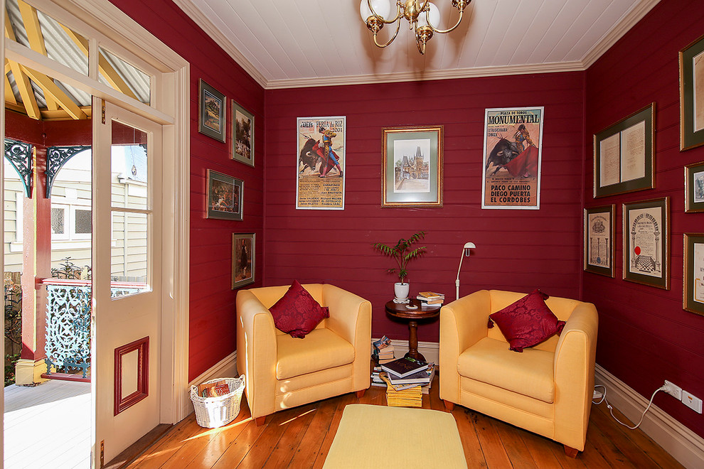Immagine di un piccolo soggiorno tradizionale chiuso con pareti rosse e pavimento in legno massello medio