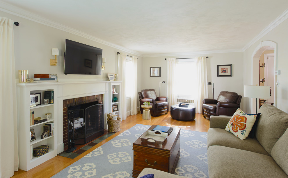 Mittelgroßes, Abgetrenntes Klassisches Wohnzimmer mit grauer Wandfarbe, hellem Holzboden, Kamin, Kaminumrandung aus Backstein und TV-Wand in Boston