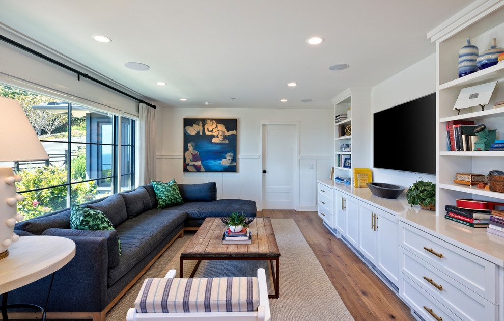Immagine di un soggiorno classico chiuso con TV a parete, pareti bianche, pavimento in legno massello medio e pavimento marrone