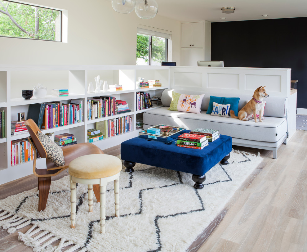 Idee per un soggiorno chic con libreria, pareti multicolore e parquet chiaro