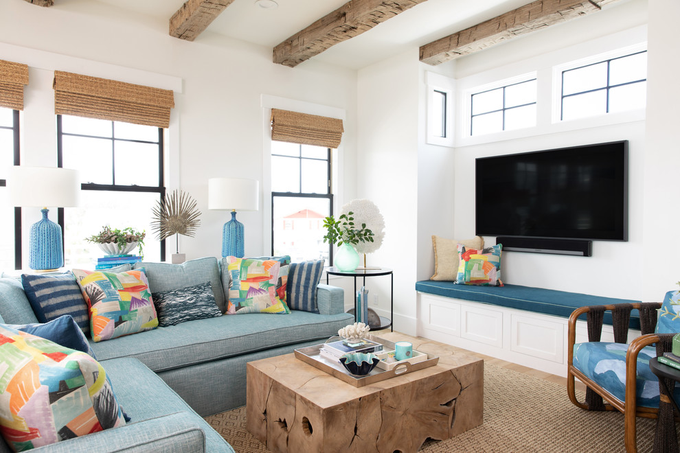 Источник вдохновения для домашнего уюта: гостиная комната в морском стиле с белыми стенами, телевизором на стене и синим диваном без камина