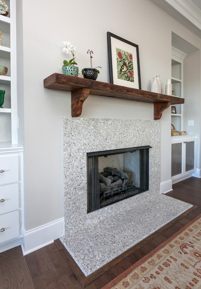 Photo of a medium sized contemporary games room in Charleston with grey walls, dark hardwood flooring, a standard fireplace, a plastered fireplace surround, no tv and brown floors.