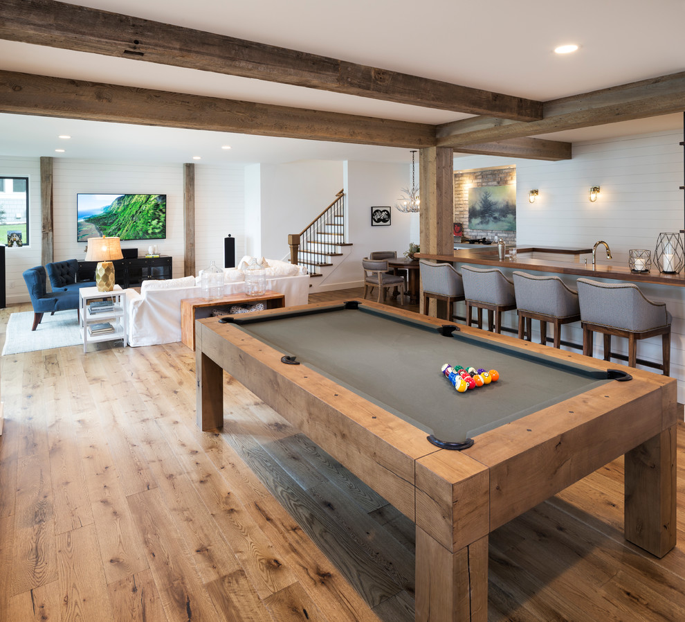 Inspiration for a classic open plan games room in Minneapolis with white walls, medium hardwood flooring, a wall mounted tv and brown floors.