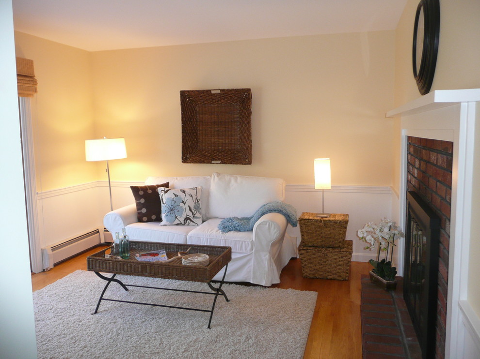 Foto de sala de estar cerrada tradicional pequeña con paredes amarillas, suelo de madera en tonos medios, todas las chimeneas y marco de chimenea de madera