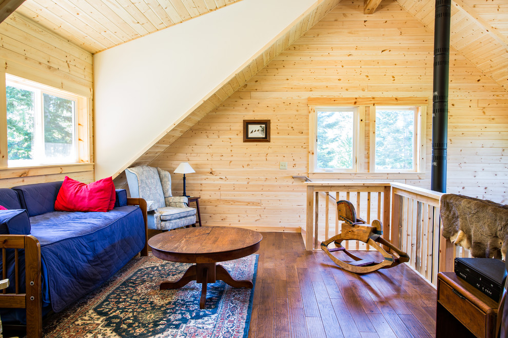 Mittelgroßes Rustikales Wohnzimmer im Loft-Stil, ohne Kamin mit beiger Wandfarbe, dunklem Holzboden, freistehendem TV und braunem Boden in Seattle
