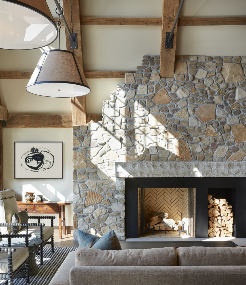 Diseño de sala de estar abierta rural grande sin televisor con suelo de madera en tonos medios, todas las chimeneas, marco de chimenea de piedra, paredes beige y suelo marrón