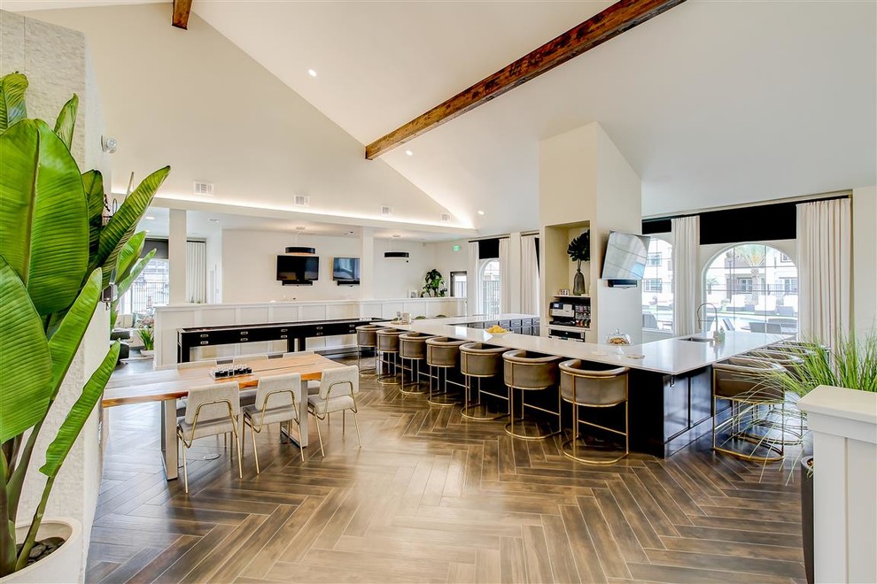 Imagen de sala de juegos en casa abierta actual extra grande con paredes beige, suelo vinílico y suelo marrón
