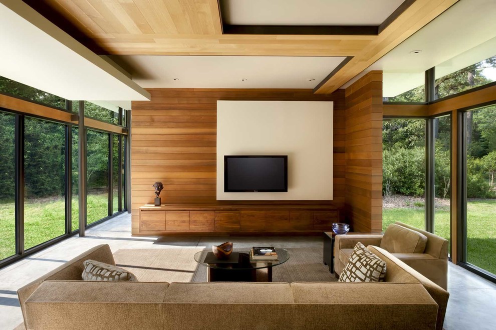 Exemple d'une grande salle de séjour tendance ouverte avec un mur beige, sol en béton ciré et un téléviseur fixé au mur.