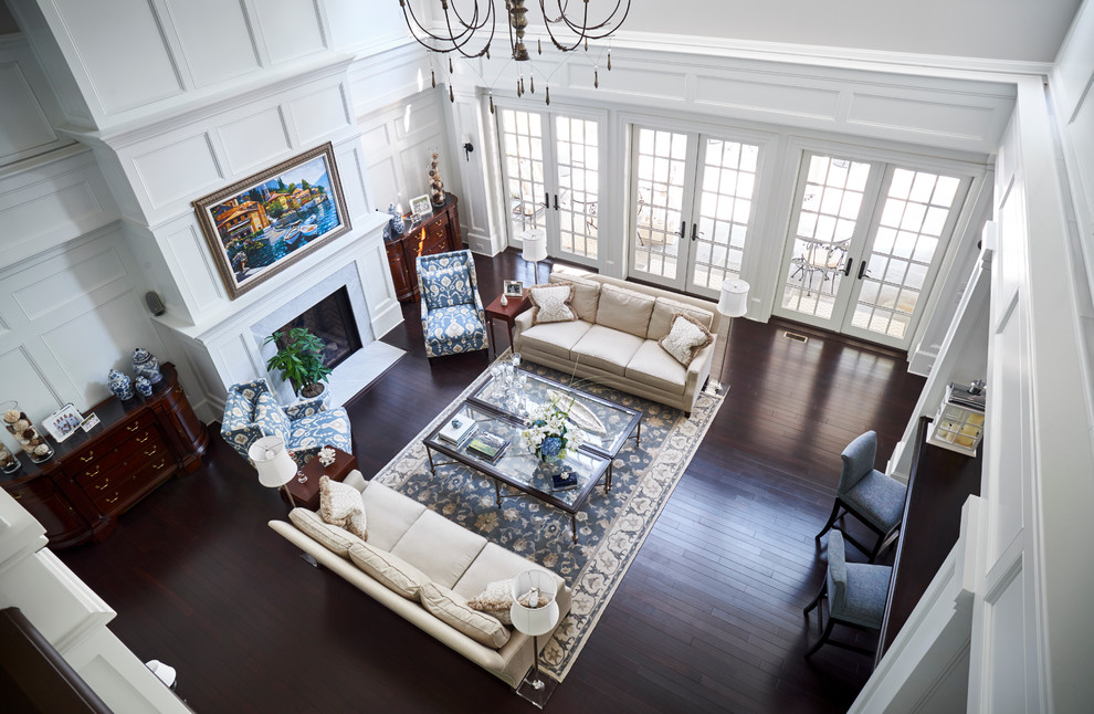 Cette image montre une très grande salle de séjour design ouverte avec un bar de salon, un mur blanc, parquet foncé, une cheminée standard, un manteau de cheminée en bois et aucun téléviseur.