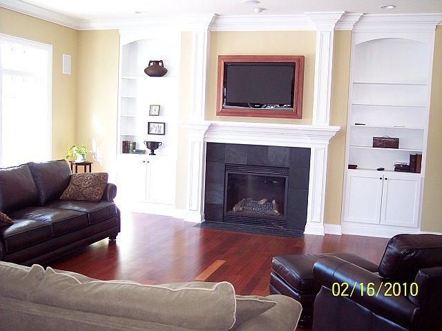 Aménagement d'une grande salle de séjour classique ouverte avec un mur beige, parquet foncé, une cheminée standard, un manteau de cheminée en carrelage et un téléviseur encastré.