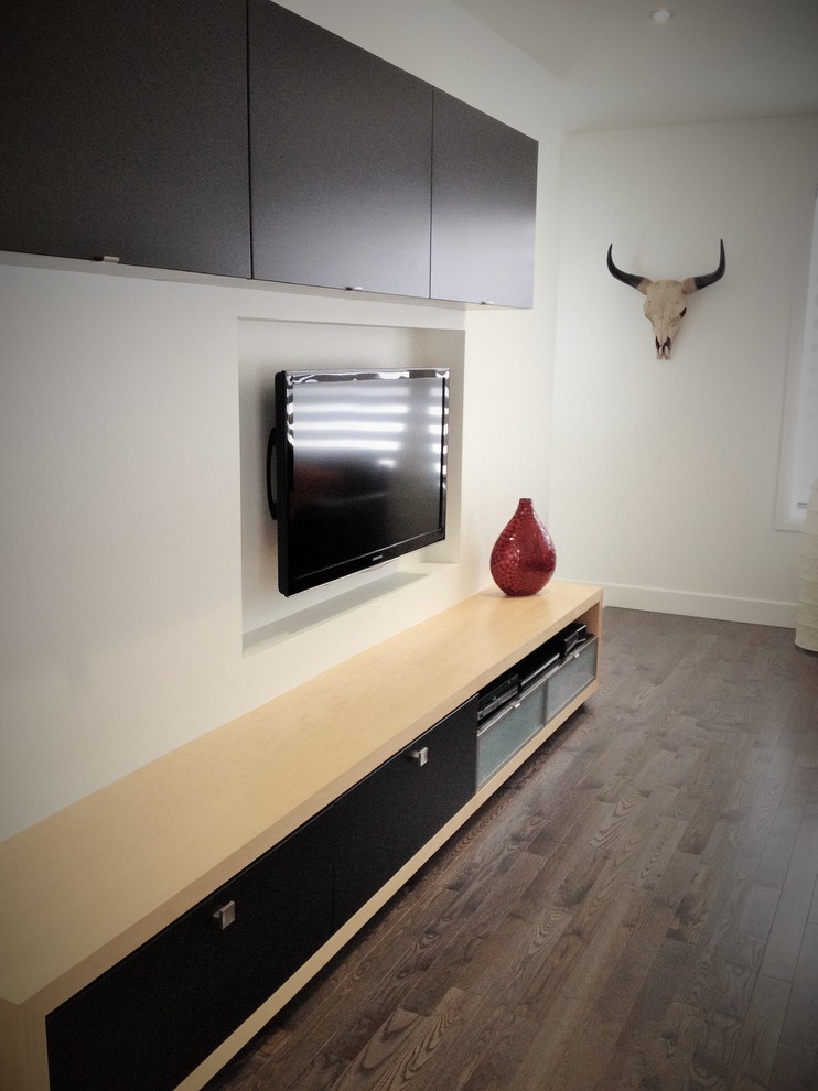 Ejemplo de sala de estar abierta minimalista grande con paredes blancas, suelo de madera en tonos medios y televisor colgado en la pared