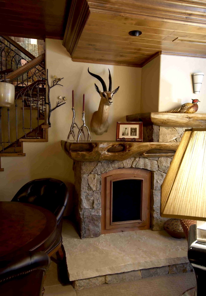 Foto de sala de estar rural grande con suelo de travertino, todas las chimeneas y marco de chimenea de piedra