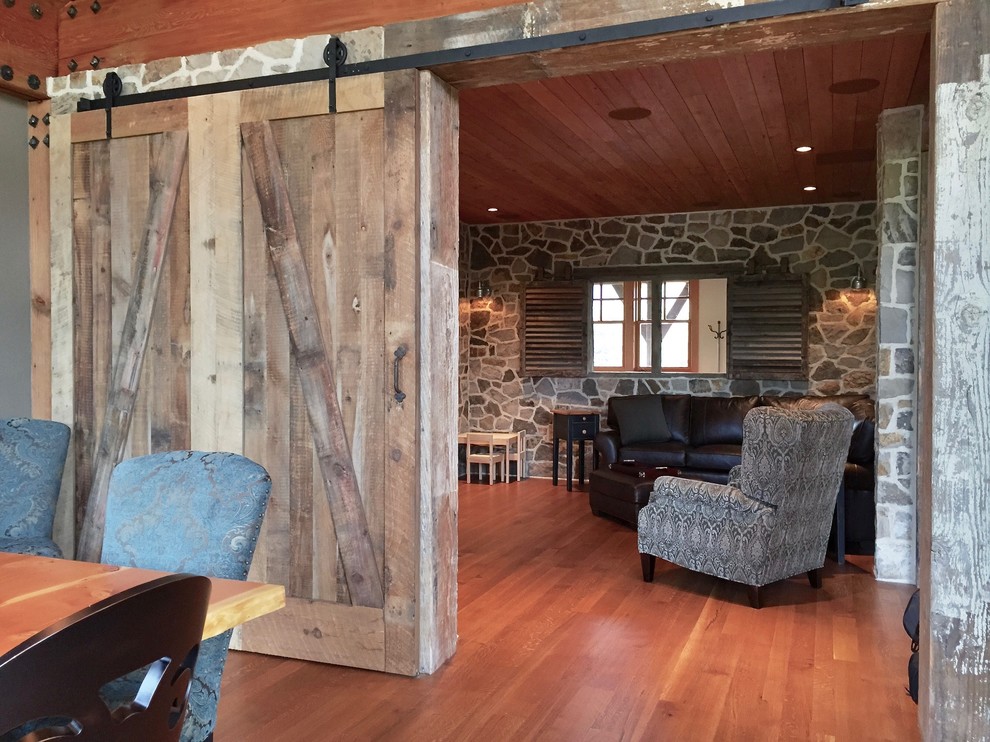 This is an example of a large rustic enclosed games room in Denver with a reading nook, light hardwood flooring and a wall mounted tv.
