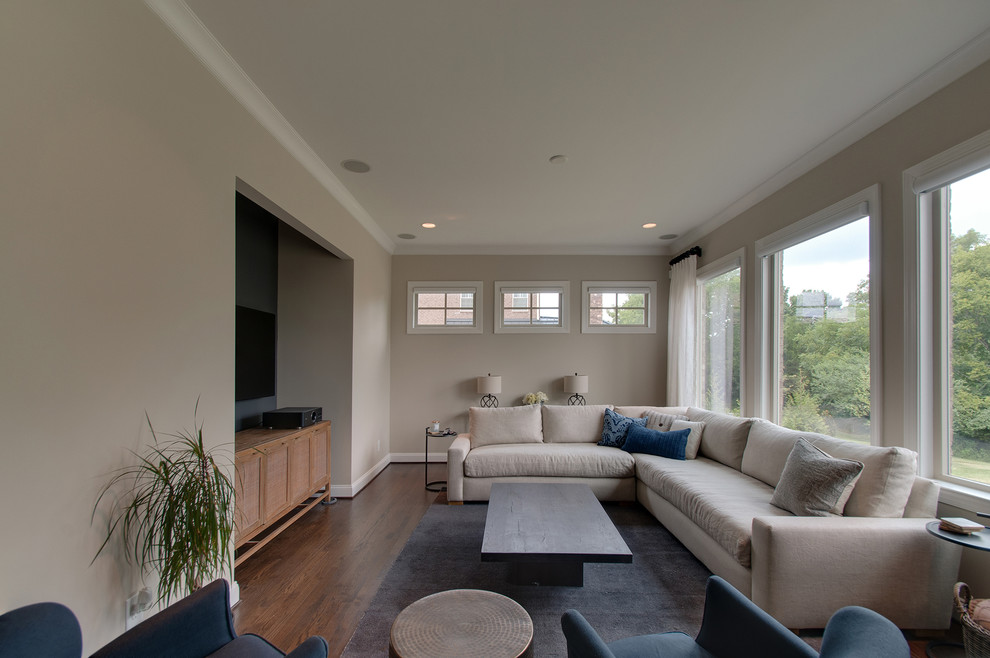 На фото: изолированная гостиная комната в стиле ретро с серыми стенами, темным паркетным полом, телевизором на стене и коричневым полом с
