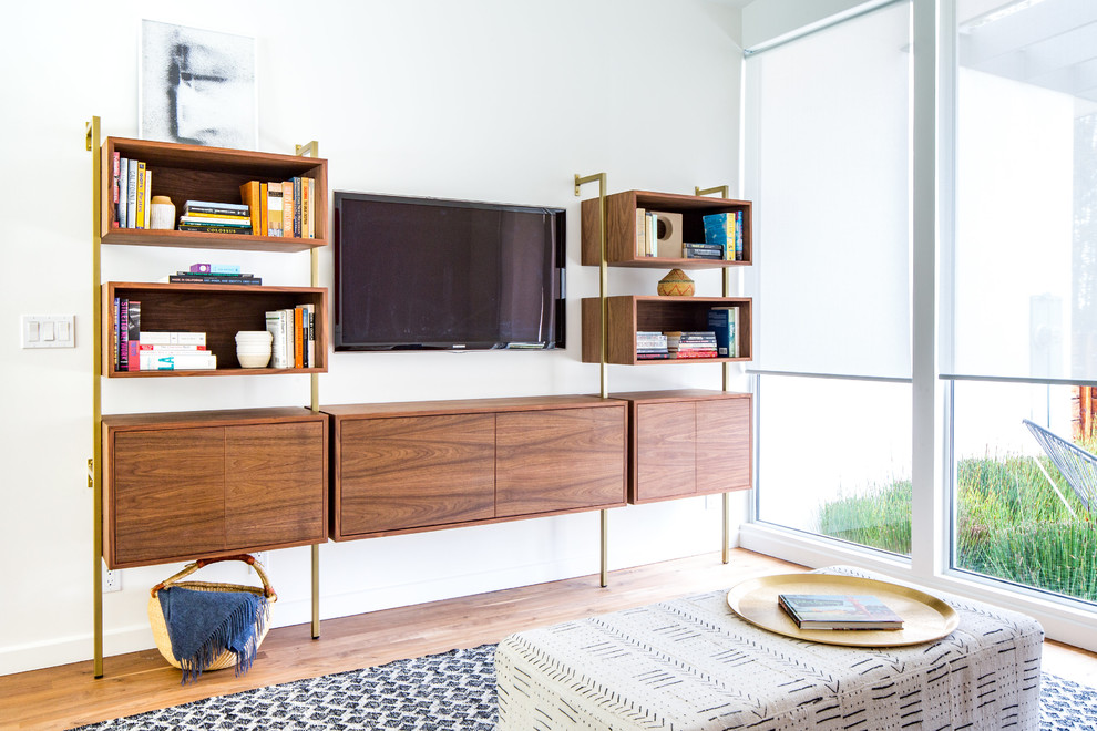 Cette photo montre une salle de séjour rétro avec un mur blanc, un sol en bois brun, un téléviseur fixé au mur et un sol marron.