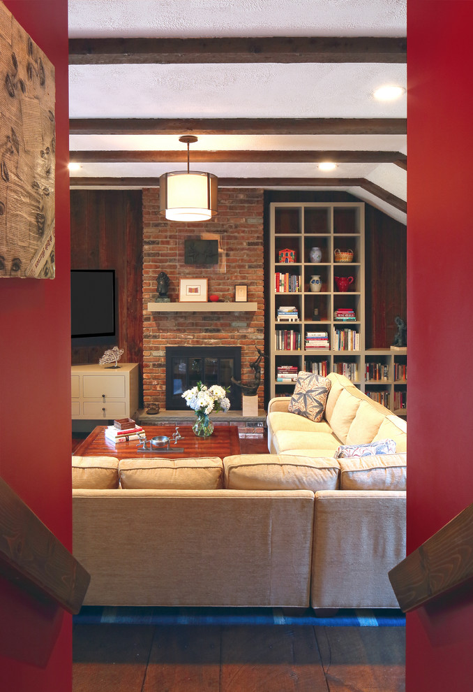 Bild på ett mellanstort vintage avskilt allrum, med röda väggar, mörkt trägolv, en standard öppen spis, en spiselkrans i tegelsten och en väggmonterad TV