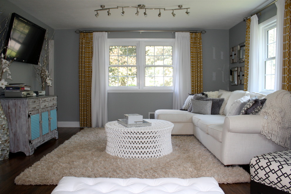 Diseño de sala de estar abierta minimalista de tamaño medio sin chimenea con televisor colgado en la pared, paredes grises y suelo de madera oscura