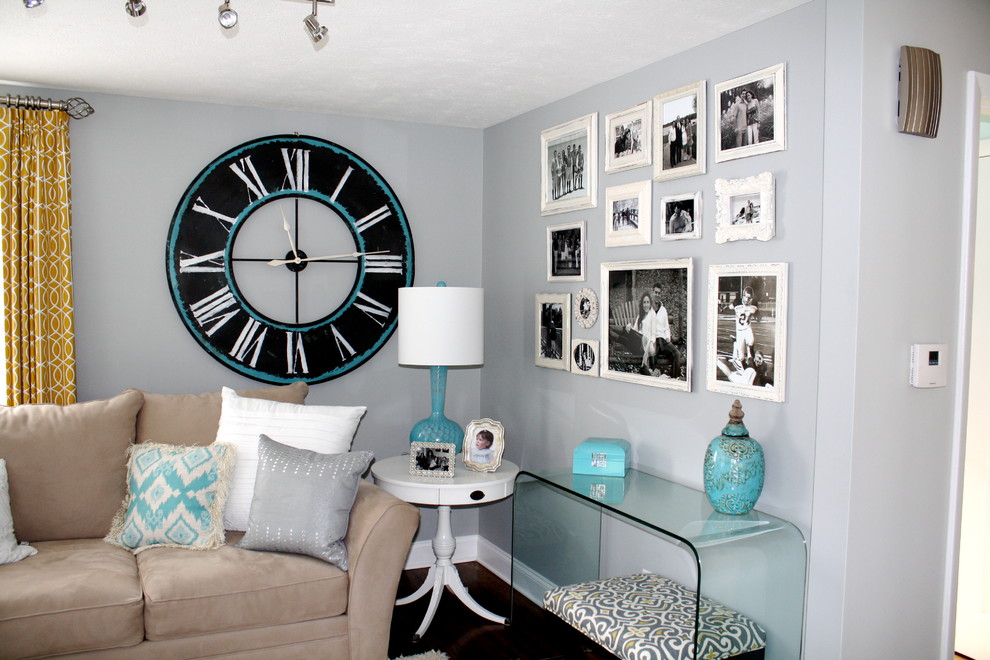 Ejemplo de sala de estar minimalista de tamaño medio sin chimenea con televisor colgado en la pared, paredes grises y suelo de madera oscura