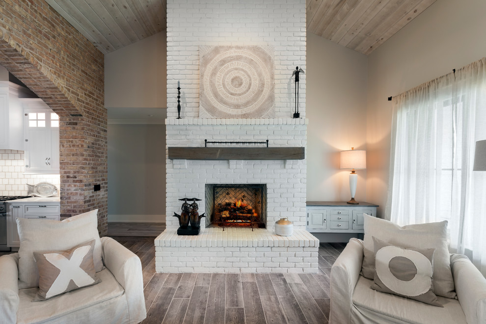 デトロイトにある高級な中くらいなシャビーシック調のおしゃれなオープンリビング (ベージュの壁、セラミックタイルの床、標準型暖炉、レンガの暖炉まわり、テレビなし、グレーの床) の写真