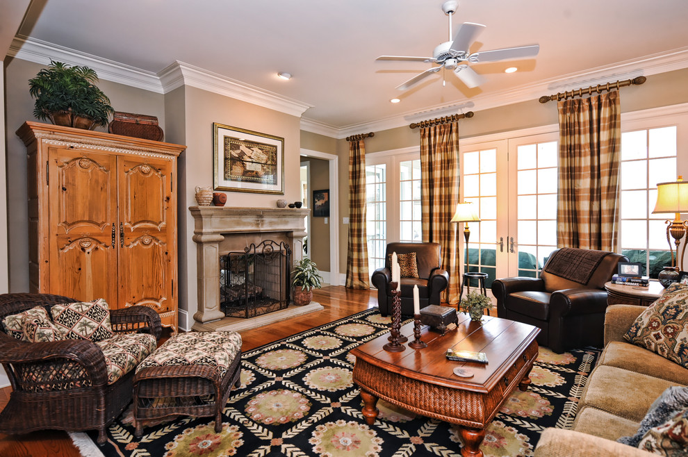 Example of a classic enclosed medium tone wood floor living room design in Charlotte with beige walls and a standard fireplace