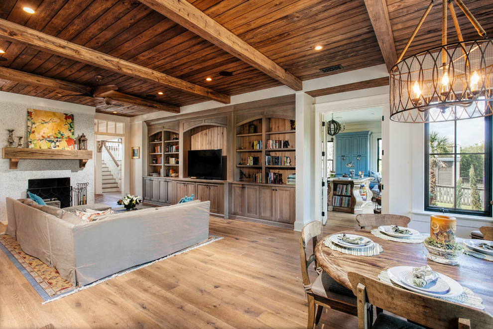 Ejemplo de sala de estar con biblioteca abierta clásica con paredes blancas, suelo de madera clara, televisor independiente, todas las chimeneas y marco de chimenea de piedra