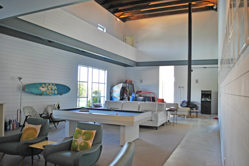 Cette photo montre une salle de séjour nature ouverte avec un mur blanc, sol en béton ciré et cheminée suspendue.