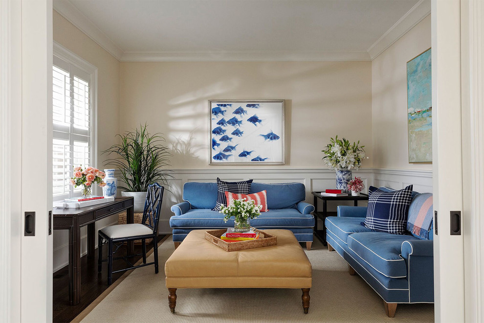 На фото: изолированная гостиная комната в морском стиле с бежевыми стенами, темным паркетным полом и синим диваном без камина с