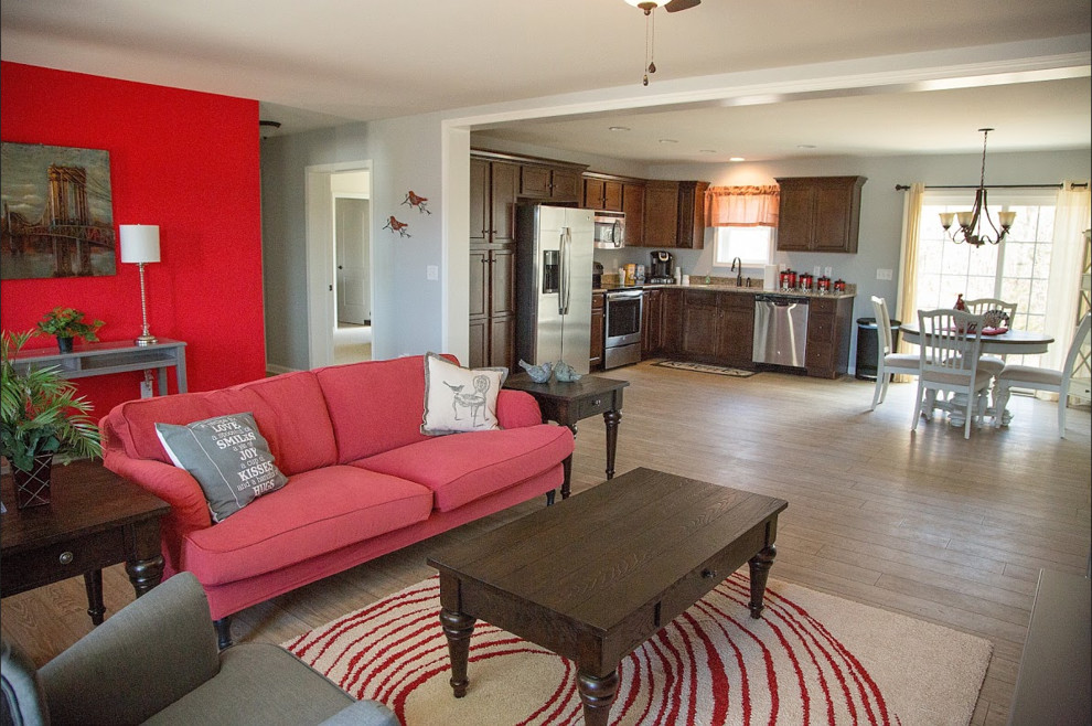 Diseño de sala de estar abierta clásica grande sin chimenea con paredes multicolor, suelo de madera clara y televisor independiente