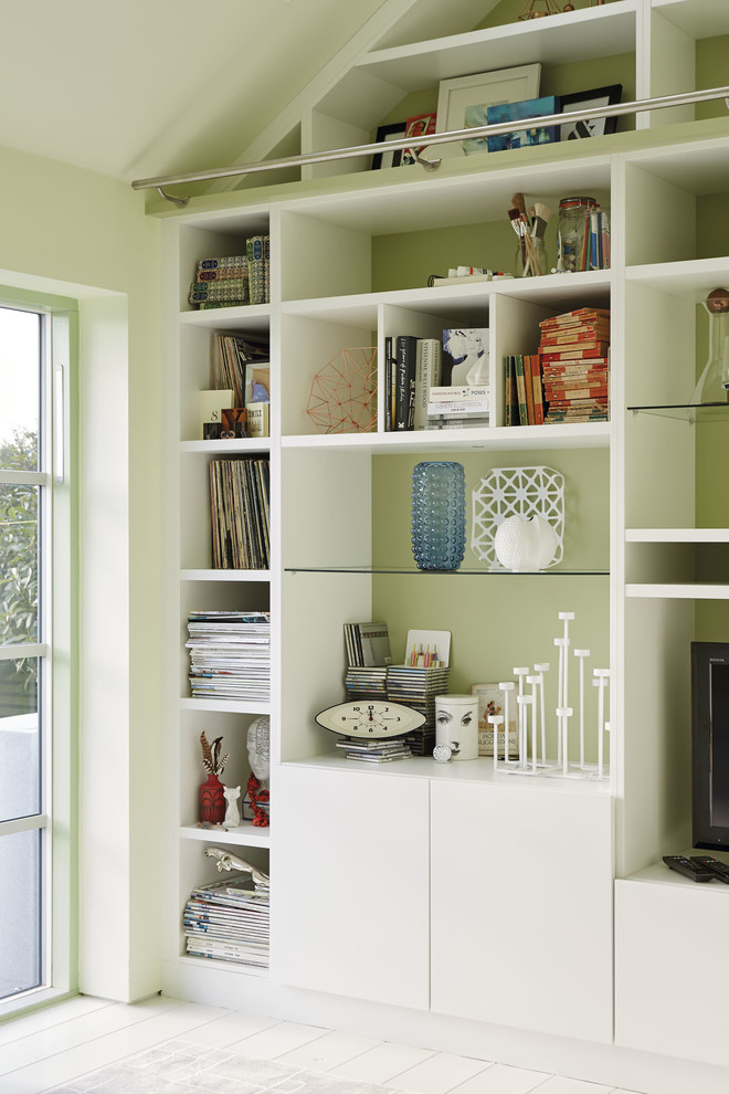 Idée de décoration pour une salle de séjour design ouverte avec une bibliothèque ou un coin lecture, un mur vert, parquet clair, un téléviseur encastré et un sol blanc.