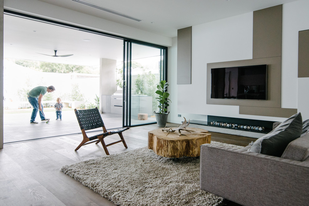 Großes, Offenes Modernes Wohnzimmer mit weißer Wandfarbe, dunklem Holzboden, Eckkamin, Kaminumrandung aus Stein und TV-Wand in Adelaide