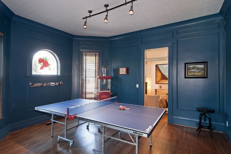 Exemple d'une grande salle de séjour moderne fermée avec salle de jeu, un mur bleu et un sol en bois brun.
