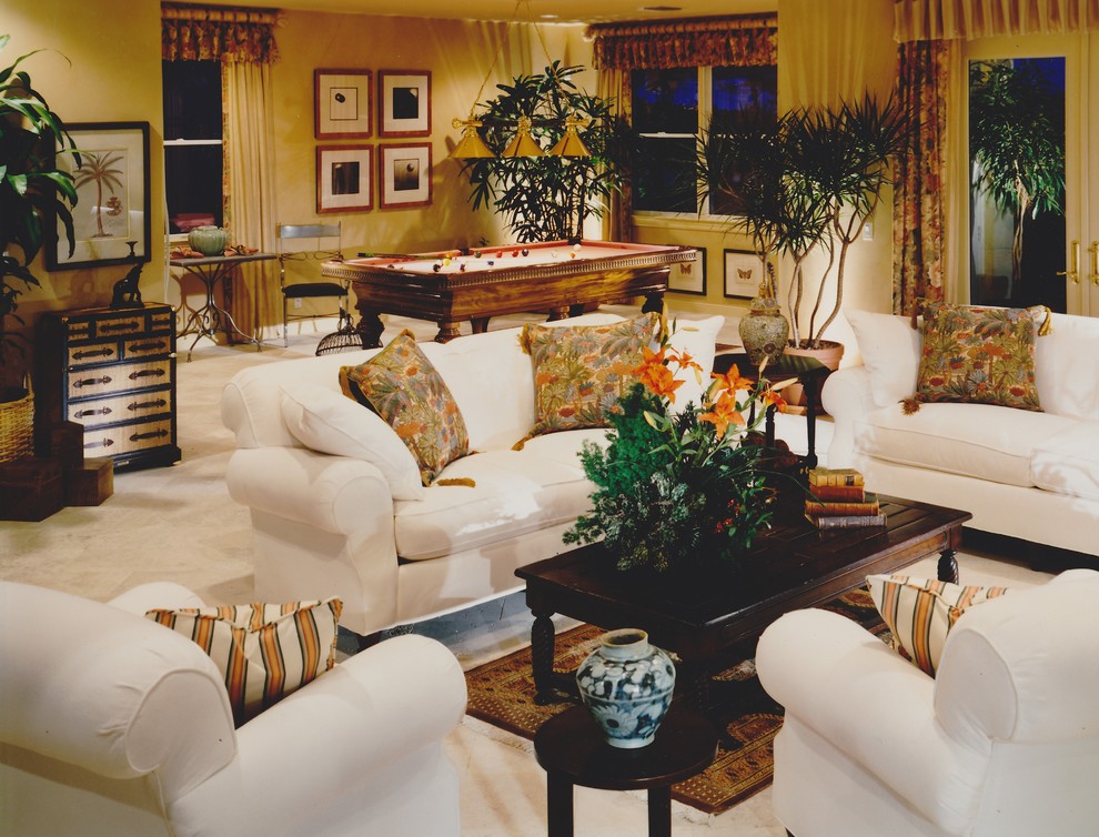 Esempio di un soggiorno tropicale di medie dimensioni e stile loft con sala giochi, pareti arancioni e pavimento in travertino