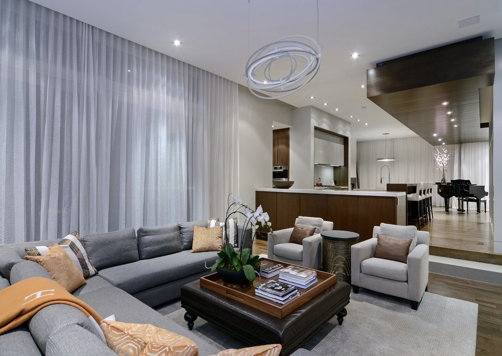 Diseño de sala de estar contemporánea con paredes grises y suelo de madera en tonos medios
