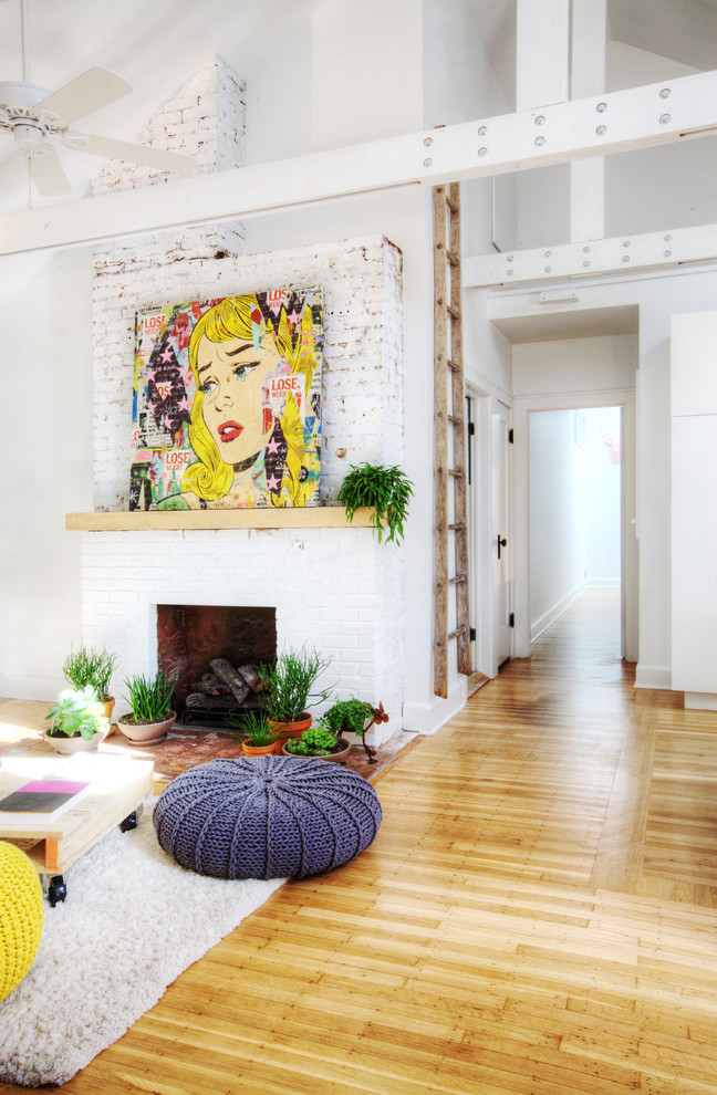 Foto de sala de estar ecléctica de tamaño medio con paredes blancas, suelo de madera clara, todas las chimeneas, marco de chimenea de ladrillo y alfombra