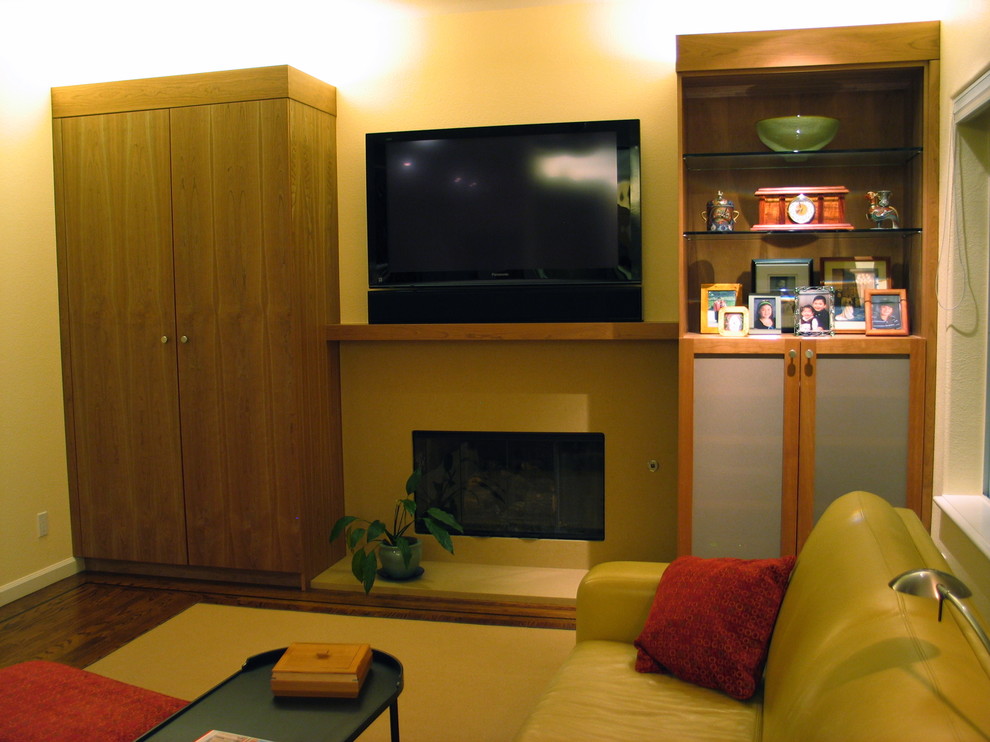 Photo of a large contemporary open plan games room in San Francisco with yellow walls, dark hardwood flooring, a standard fireplace, a plastered fireplace surround, a built-in media unit and brown floors.
