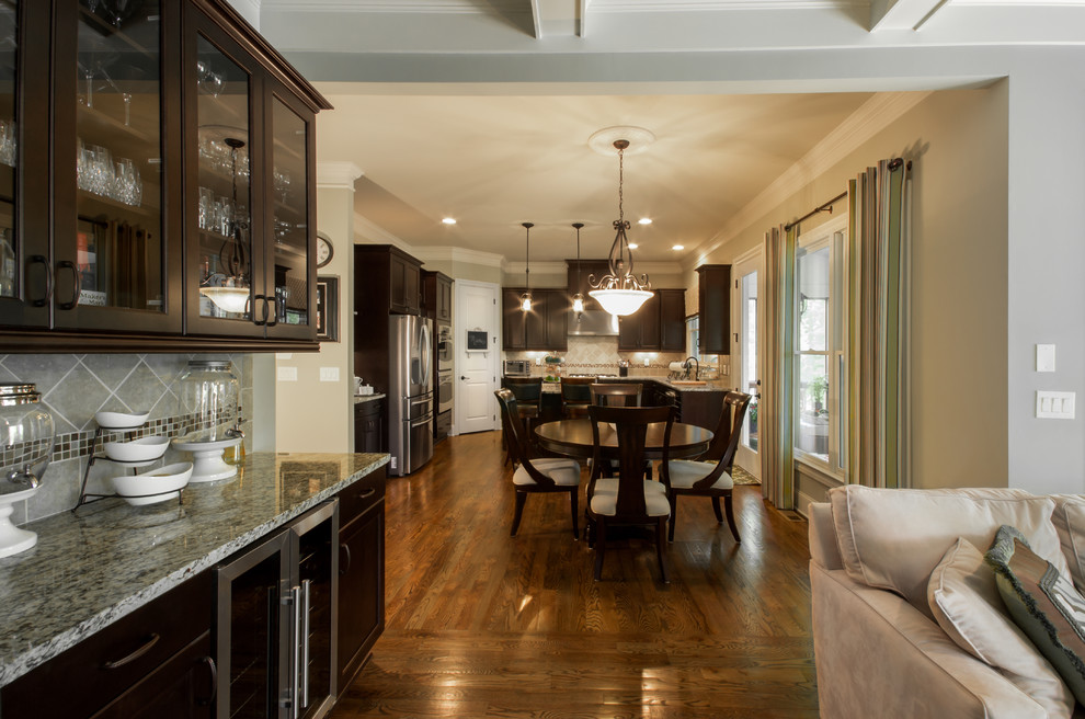 Großes, Offenes Klassisches Wohnzimmer mit Hausbar, beiger Wandfarbe, braunem Holzboden, Kamin und Kaminumrandung aus Stein in Atlanta