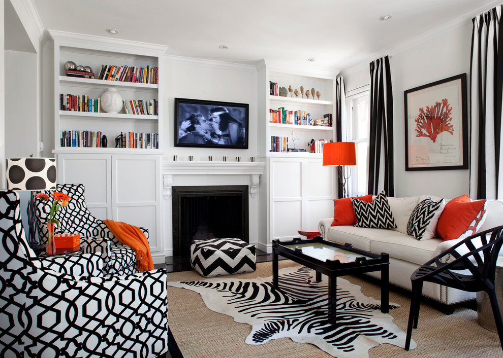 На фото: открытая гостиная комната среднего размера в современном стиле с белыми стенами, стандартным камином, телевизором на стене, с книжными шкафами и полками, темным паркетным полом, фасадом камина из дерева, коричневым полом и ковром на полу с