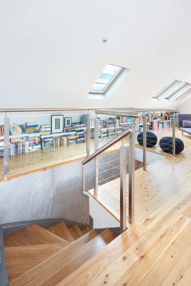Bild på ett mellanstort funkis allrum på loftet, med ett bibliotek, vita väggar, ljust trägolv och brunt golv