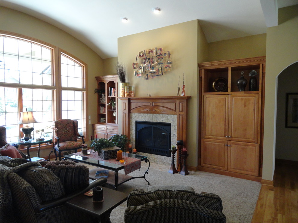 Foto de sala de estar abierta clásica renovada grande con paredes beige, moqueta, todas las chimeneas, marco de chimenea de madera y televisor retractable