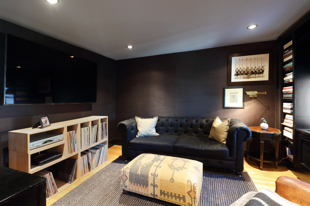 Inspiration for a medium sized modern enclosed games room in New York with a reading nook, black walls, light hardwood flooring, no fireplace, a wall mounted tv and beige floors.