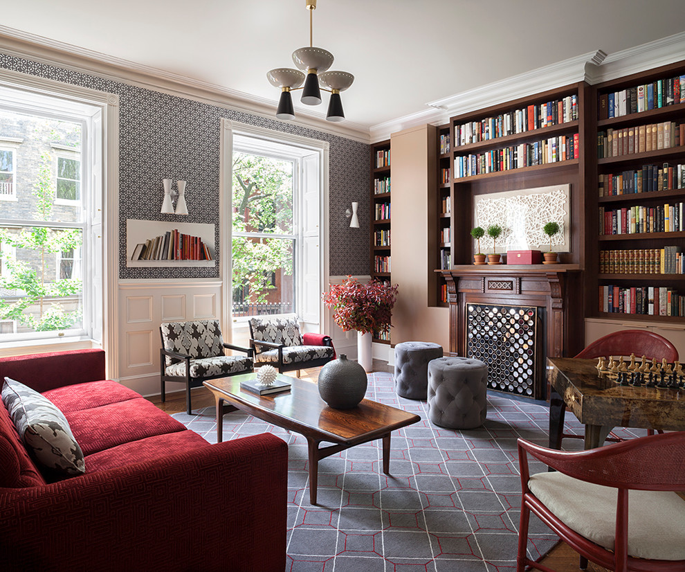 Cette image montre une salle de séjour traditionnelle de taille moyenne avec une bibliothèque ou un coin lecture, une cheminée standard, un manteau de cheminée en bois, moquette et un mur multicolore.