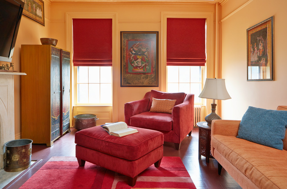 Foto de sala de estar cerrada clásica renovada con parades naranjas, suelo de madera pintada, todas las chimeneas, marco de chimenea de piedra y televisor colgado en la pared