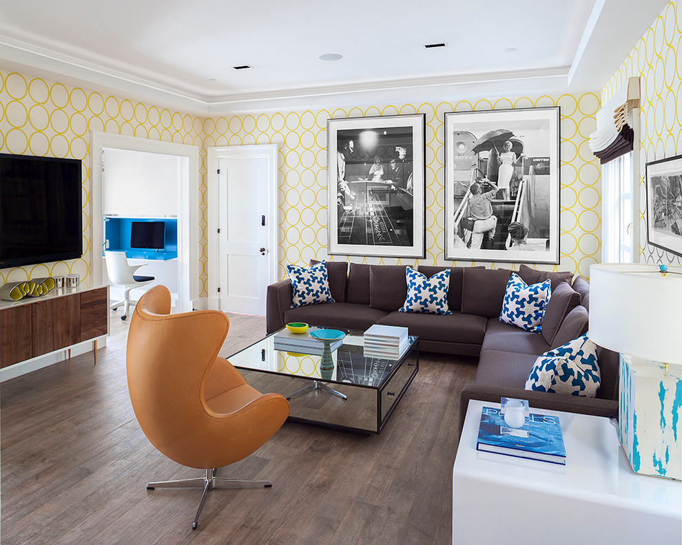 Стильный дизайн: изолированная гостиная комната среднего размера в современном стиле с желтыми стенами, темным паркетным полом и телевизором на стене - последний тренд